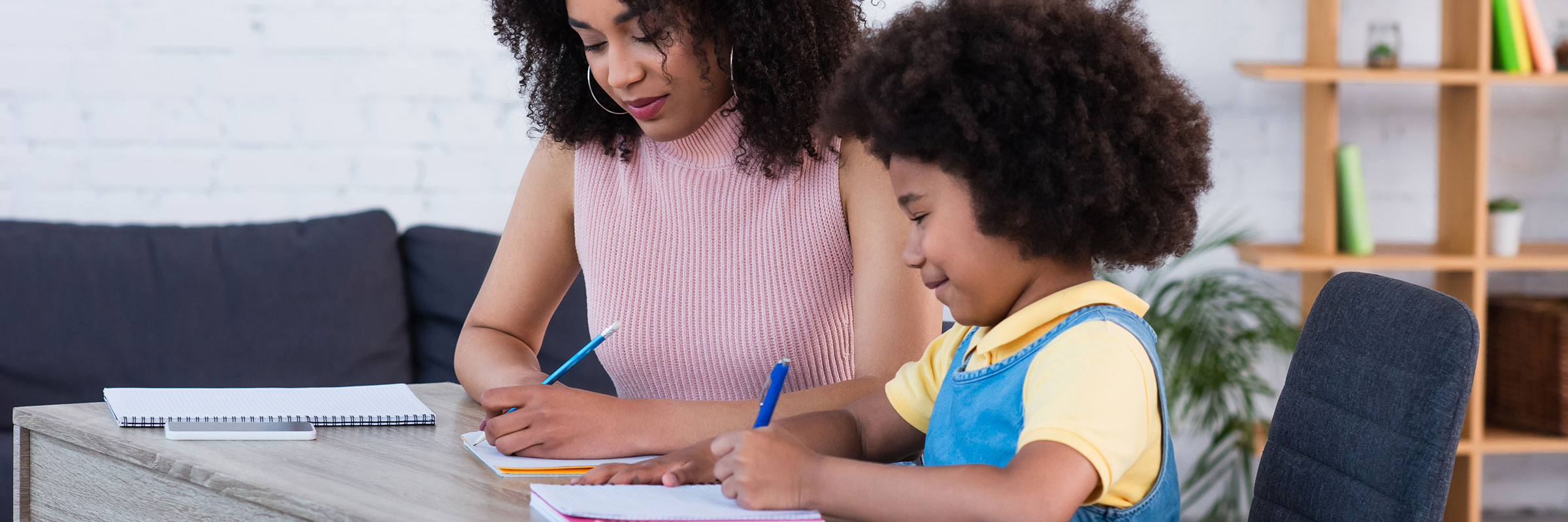 Mother and child sitting at desk working on homework together